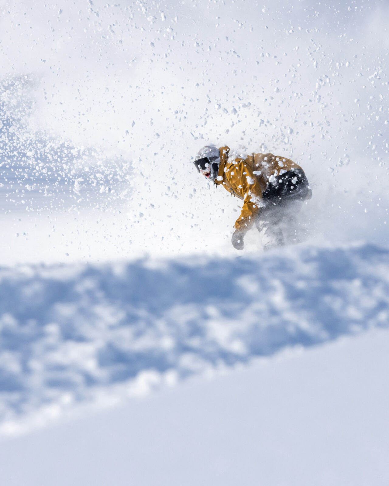 Smiling Excited Adult Male Snowboarder Tyler Morty Does Toeside Carve In Blower Snow With powder Eruption Behind From Powder Slash Closeup At Bogus Basin On A Bluebird Day Winter 2021 Photo By Luke Tokunaga _1638x2048