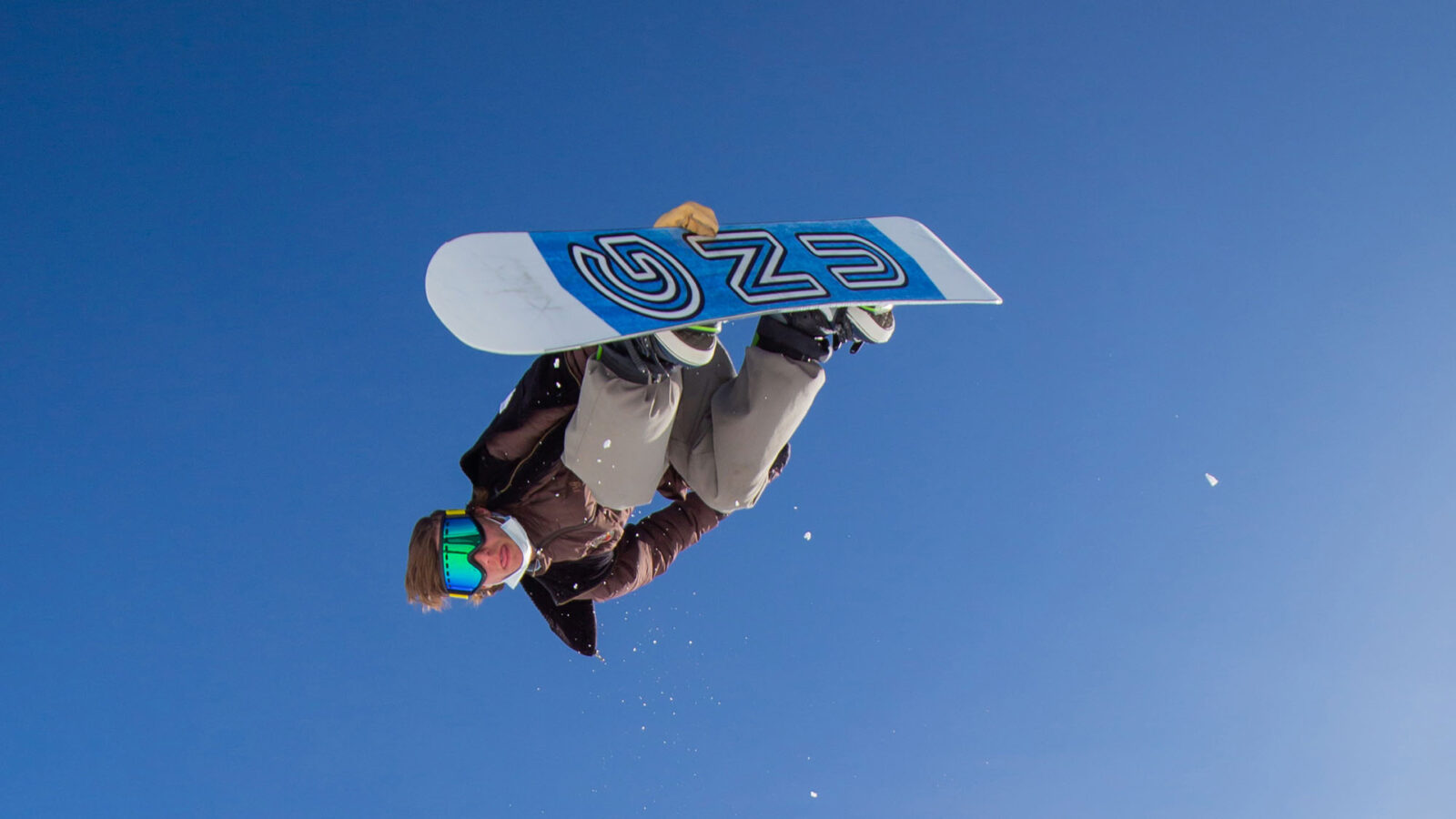 Snowboarder In Mid Air Doing Back Grab Trick With GNU Board And Blue Sky Winter 2022 At Bogus Basin Mountain Recreation Area 1920px1080px