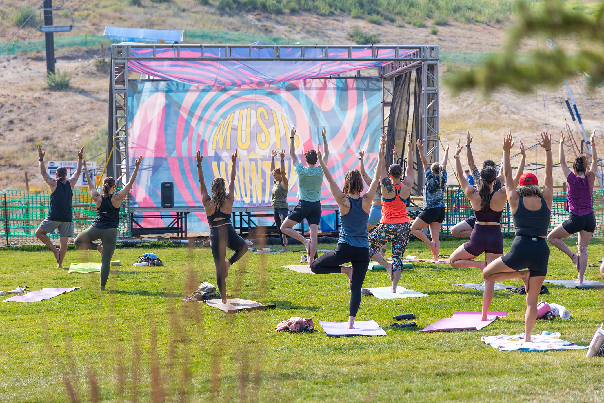 Yoga On The Mountain With Colorful Blue And Pink Stage In Background On The Lawn Summer 2024 At Bogus Basin 08 20 24 Photo By Cassidy Carter 2084x 1389
