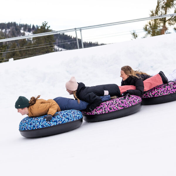 Three Female College Students Sliding Down The Winter Tubing Hill In A Line With Trees In Background Winter 2024 At Bogus Basin Mountain Recreation Area Photo By Cassidy Carter 1920px1080px